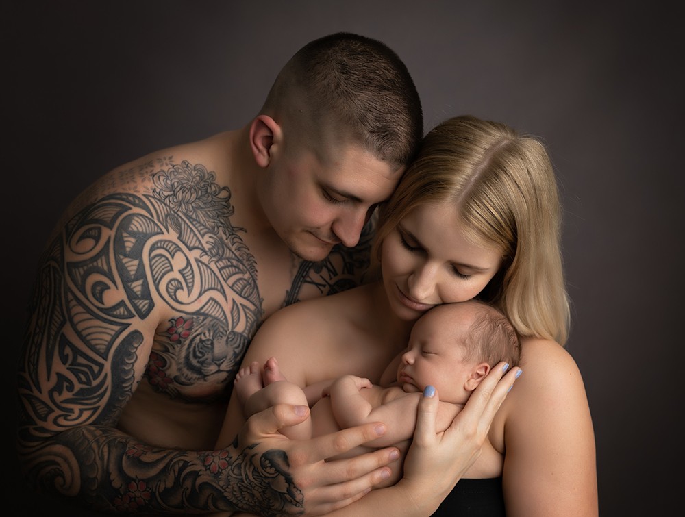 Family with newborn baby boy in a review of newborn photographer