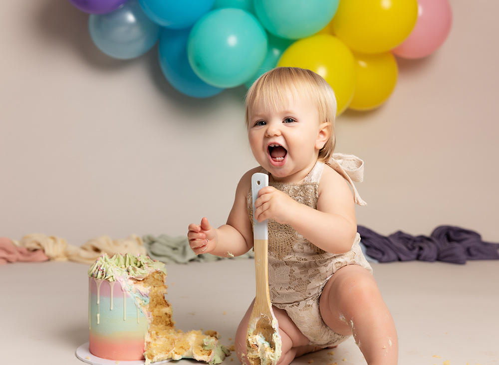 Cake Smash baby girl on her first birthday with balloons
