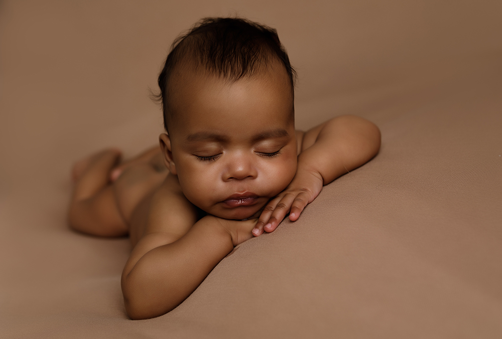 Sleeping baby boy on a brown blanket in an Older newborn photoshoot milton keynes
