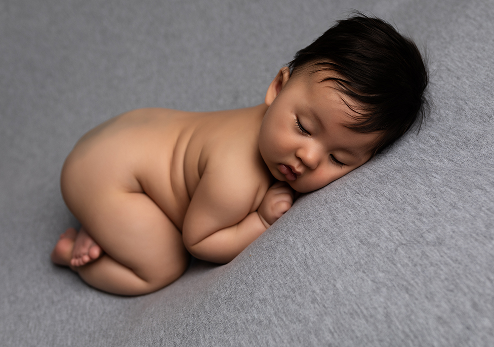 Sleeping baby boy on grey blanket in Older newborn photoshoot milton keynes